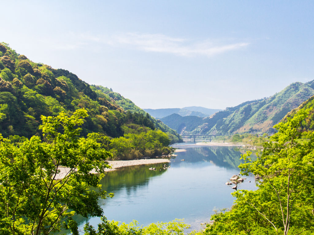 翠綠山色倒映在日本清澈的四萬十川上,景色優美。